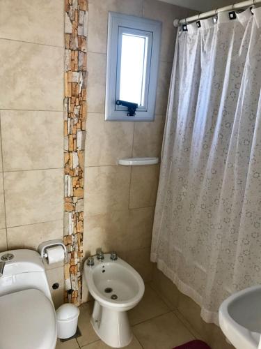 a bathroom with a toilet sink and a shower curtain at Terraza Marina in Ostende