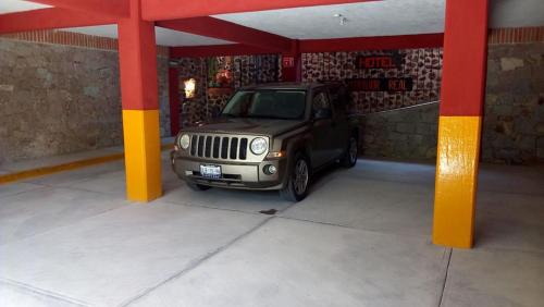 a jeep parked in a garage with red and yellow columns at Hotel Mirador Real in Bernal