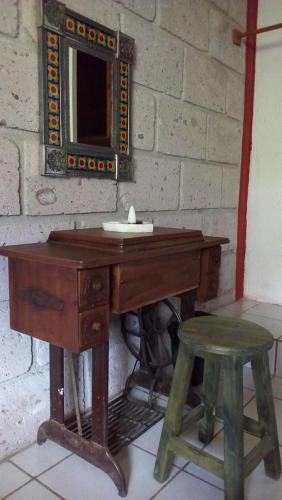 a wooden desk with a mirror and a stool at Hotel Mirador Real in Bernal