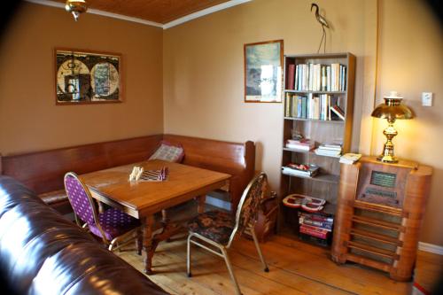 uma sala de estar com uma mesa e um sofá de couro em Eriksen Premises em Trinity