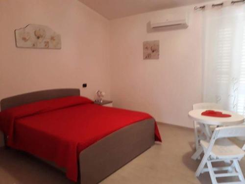 サンタ・マリーア・デル・チェドロにあるArcobaleno Magicoのベッドルーム(赤いベッド1台、白いテーブル付)