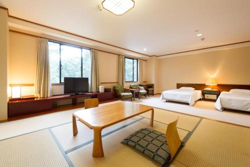 een grote kamer met 2 bedden en een tafel bij Oarai Park Hotel in Oarai