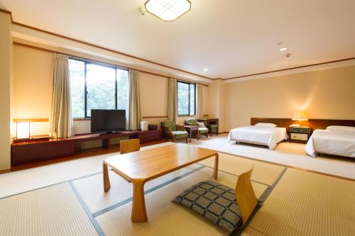 a large room with two beds and a table at Oarai Park Hotel in Oarai