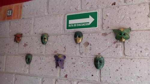 a brick wall with different types of masks on it at Hotel Mirador Real in Bernal