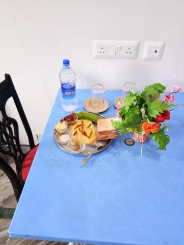 a blue table with a plate of food on it at Asian Grand Villa in Bolpur