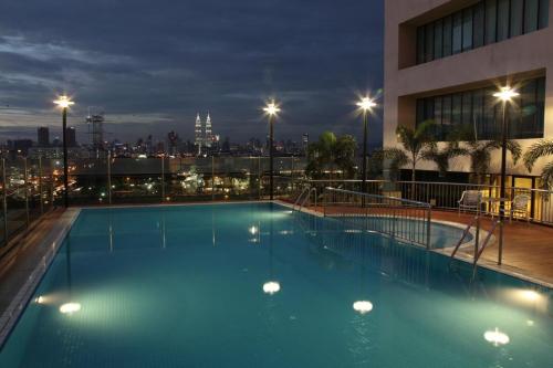 a swimming pool on the roof of a building at night at Cempaka Service Suite Unit - PRIVATELY OWNED in Kuala Lumpur