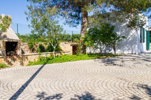 a cobblestone road with a tree and a building at Villa Vanessa in Leuca