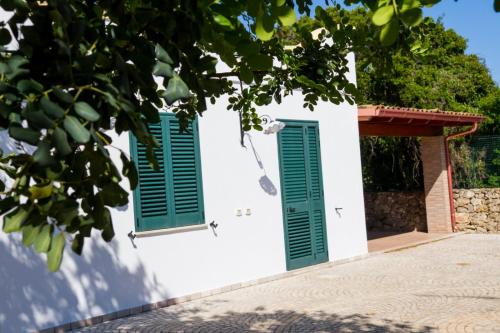 two green shuttered windows on a white building at Villa Vanessa in Leuca