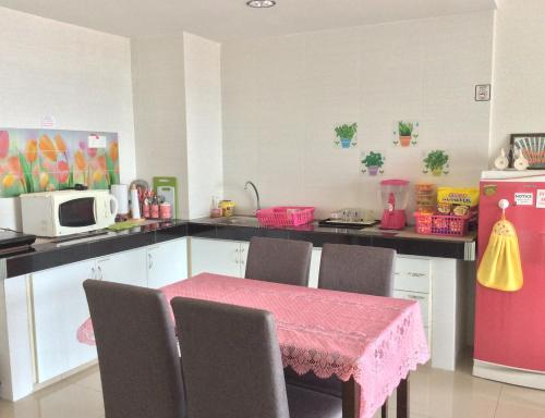 a kitchen with a pink table and a red refrigerator at Syafiq Suite in Kota Bharu