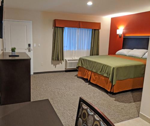 a hotel room with a bed and a window at Epic Hotel in Pico Rivera