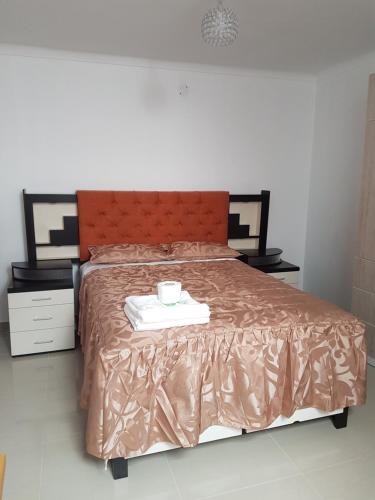 a bed with a brown comforter and a cup on it at Nino´s Residence Departamentos VIP Amoblados in Tacna