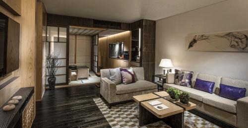 a living room with a couch and a table at Four Seasons Hotel Kyoto in Kyoto
