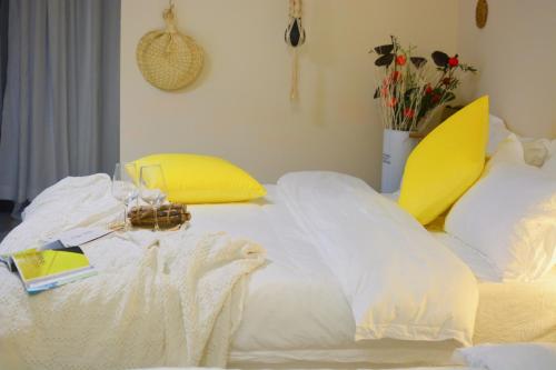 a bed with white sheets and yellow pillows at Lan House Youth Apartment in Guangzhou