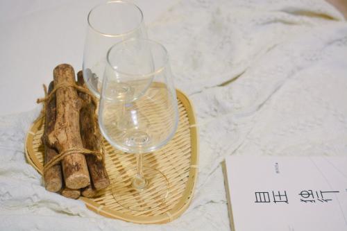 dos copas de vino sentadas en un plato en una mesa en Lan House Youth Apartment en Guangzhou