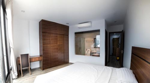 a bedroom with a white bed and a wooden door at Irest Apartment in Hanoi