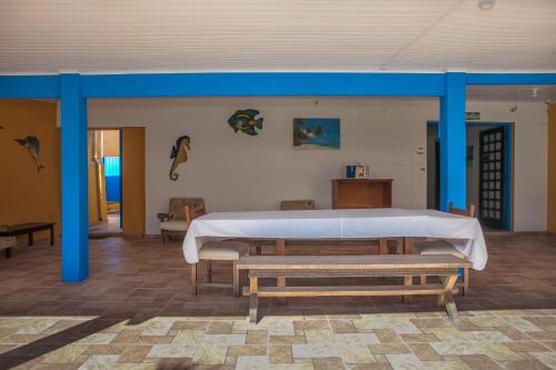 a room with a bed with blue posts and benches at Pousada da Costa in Caraguatatuba