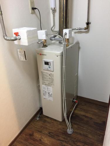 a small refrigerator in a corner of a room at Cool-Residence OTARU in Otaru