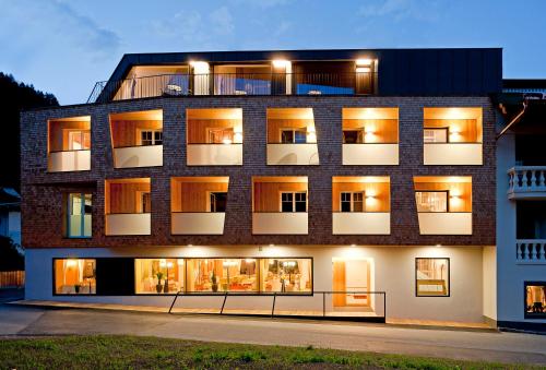a large brick building with many windows at night at derNeuwirt in Schwendau