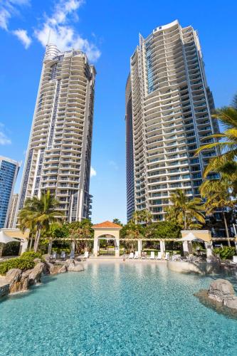 a swimming pool in the middle of two tall buildings at Holiday Holiday Chevron Renaissance Apartments in Gold Coast