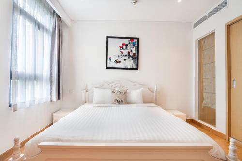 a white bedroom with a large white bed at The Ocean Apartment IDCWH B302 in Danang