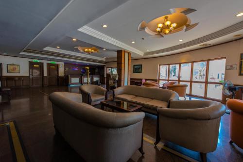 a lobby with couches and chairs in a building at Kallada Regency in Irinjālakuda
