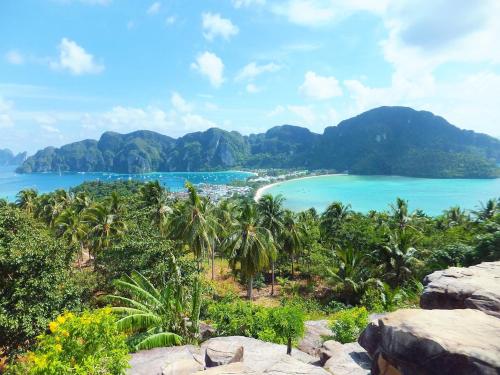 a view of a beach with palm trees and mountains at Phi Phi Maiyada Resort in Phi Phi Don