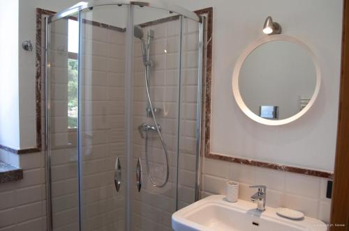ein Bad mit einer Dusche, einem Waschbecken und einem Spiegel in der Unterkunft Villa Tecla in Capri Leone