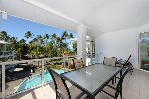a dining room with a table and chairs on a balcony at Seascape Holidays at Beaches Port Douglas in Port Douglas