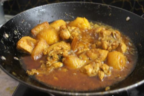 a pan of food with meat and sauce at Mansarover Home Stay in Kalimpong