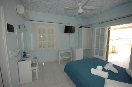 a bedroom with a bed and a desk and a window at Pension Ocean View in Naxos Chora
