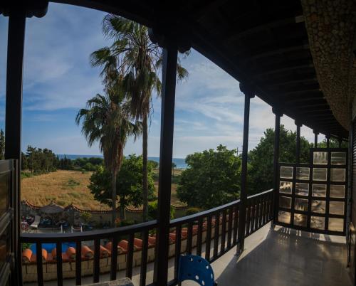 a view from the porch of a resort with a palm tree at Nepheli Hotel in Kastrosikia