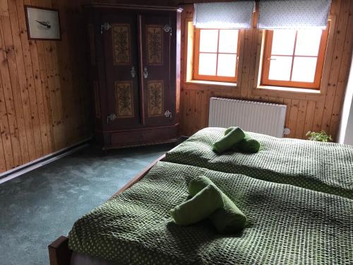 two beds in a room with green sheets at Penzion Alenka in Špindlerův Mlýn