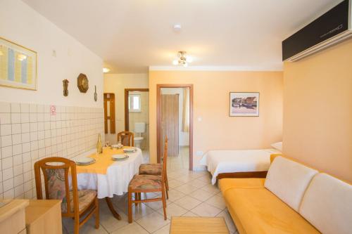 a room with a bed and a table and a couch at Apartment Smuljic in Vrboska