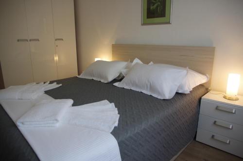 a bedroom with two beds with white pillows and a lamp at Apartments Sonja Podgora in Podgora
