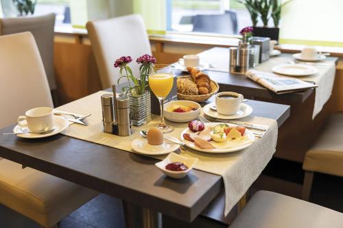 Una mesa con alimentos y bebidas para el desayuno. en Hotel Logotel, en Eisenach