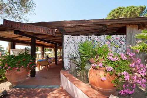 a patio with flowers and plants in large vases at Hotel Casa Rosa in Portoferraio