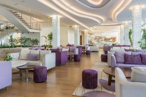 a lobby with couches and tables and purple chairs at Amadria Park Ivan in Šibenik