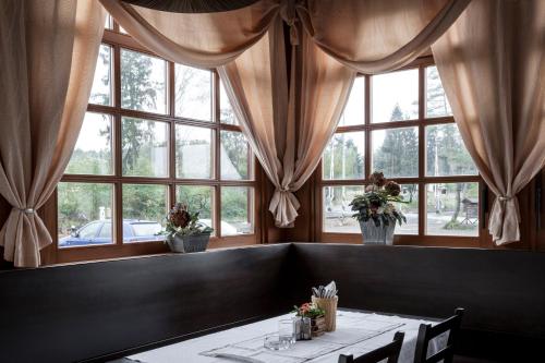 a dining room with a table and some windows at Penzion Marjána in Mníšek pod Brdy