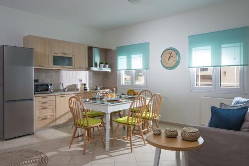 a kitchen with a table and chairs in a room at Rainbow Apartments in Stalida