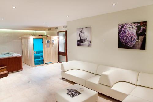 a living room with a white couch and a table at Hotel Het Landhuis in Oldenzaal
