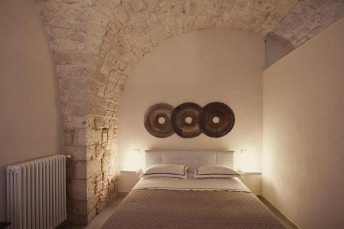 um quarto com uma cama e uma parede de pedra em Dimora a Corte em Conversano