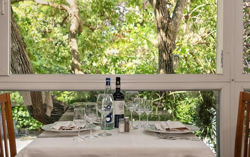 a table with wine bottles and glasses on a window at Hotel Il Caravaggio in Marina di Pietrasanta
