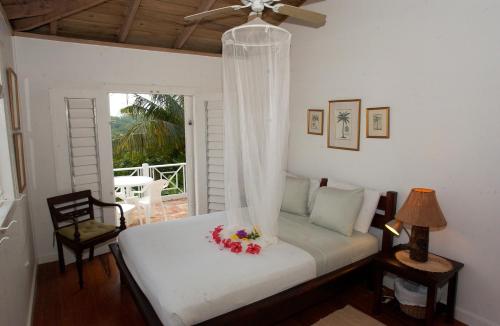 una camera con letto e ventilatore a soffitto di Tranquility Villa a Port Antonio