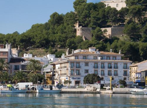 a large white building on the side of a body of water at La Posada del Mar in Denia