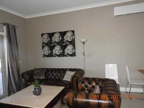 a living room with a couch and a table at Barklysuites Apartments in Rutherglen