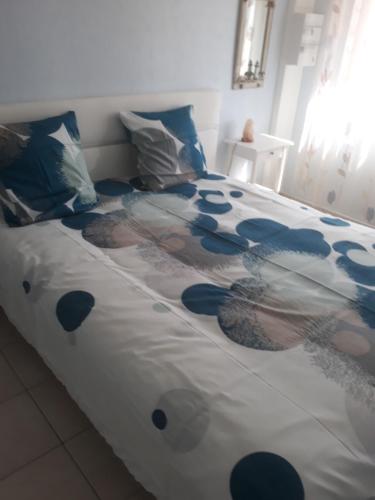 ein Bett mit einer blauen und weißen Decke drauf in der Unterkunft Gite au bord du Lac in Montville