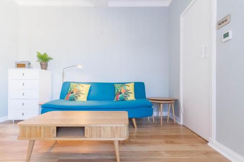 um sofá azul numa sala de estar com uma mesa de centro em Chic 1 Bed Studio Flat in Popular Bloomsbury em Londres