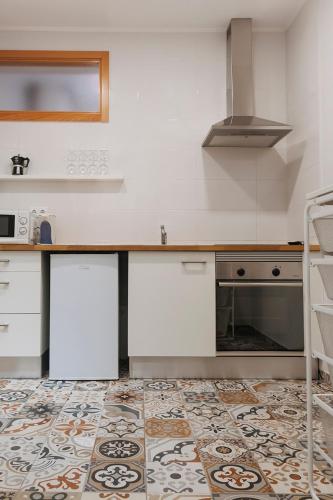 a kitchen with white cabinets and a tile floor at Casa Devesas in Vila Nova de Gaia
