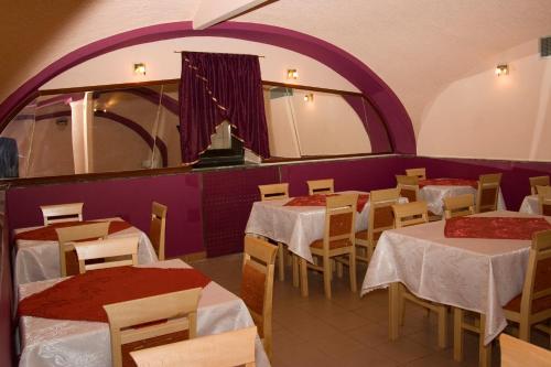 un restaurante con mesas y sillas y una pared púrpura en Apartments Klanac, en Osijek