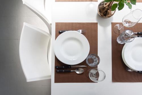 a table with a white plate and some wine glasses at Casa Devesas in Vila Nova de Gaia